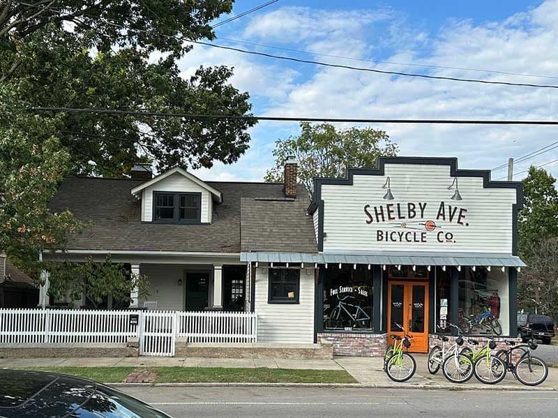 Shelby Ave Bicycle Co. storefront with bikes outside in a charming neighborhood setting.